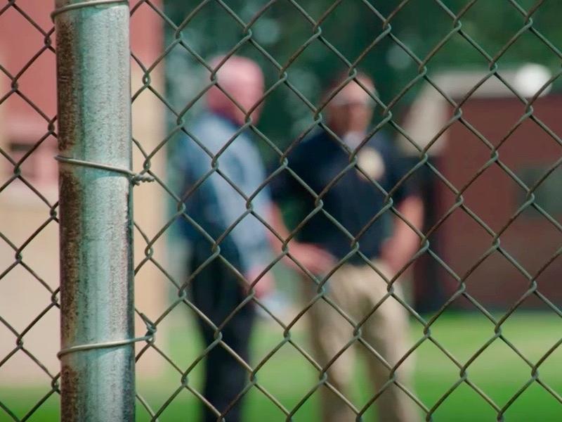 Corrections officials chat behind the fence at Pine Hills.
