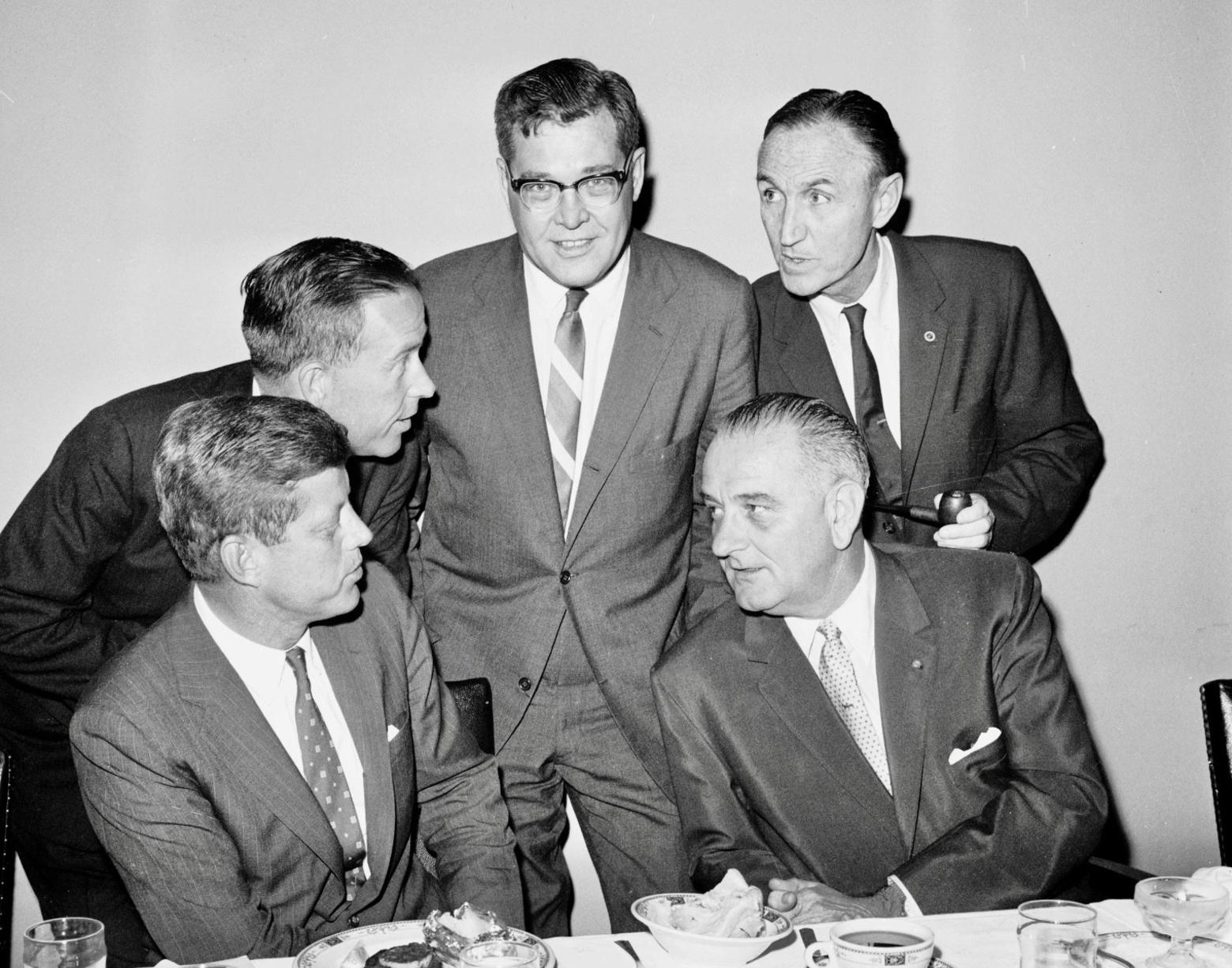 U.S. Rep. Lee Metcalf of Montana (standing, center) meets with Senate Democratic leaders in the U.S. Senate during a meal  in August 1960 prior to the fall 1960 state and national elections. Pictured are (left to right)  1960 Democratic presidential candidate Senator John F. Kennedy; Senator Henry M. Jackson, National  Democratic Party Chairman; Metcalf; Senate Majority Leader Lyndon B. Johnson; and Senate Assistant  Majority Leader Mike Mansfield, August 1960  U.S. Senate Democratic Photograph Studio photograph/courtesy Montana Historical Society
