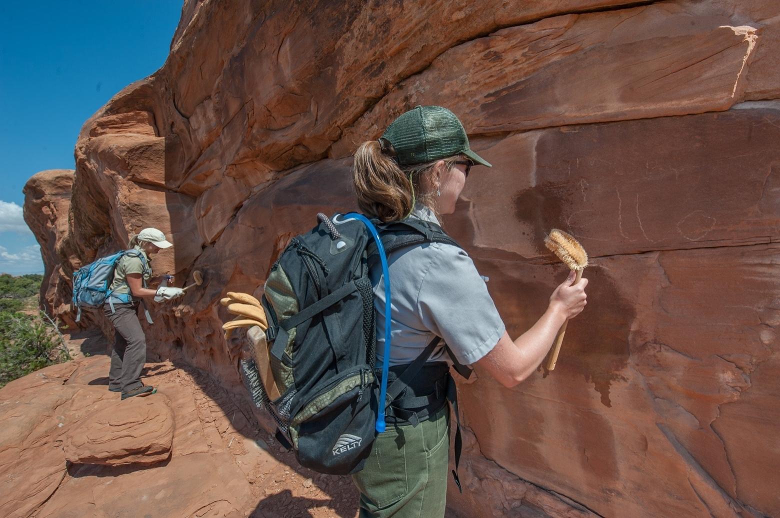 Rangers and volunteers at Arches National Park in Utah remove human graffiti scrawled into the faces of some of the natural archways. Geotagging has led to a lot more people visiting more remote sites without much of a law enforcement presence and with increased people has come vandalism. Photo courtesy Arches National Park.   