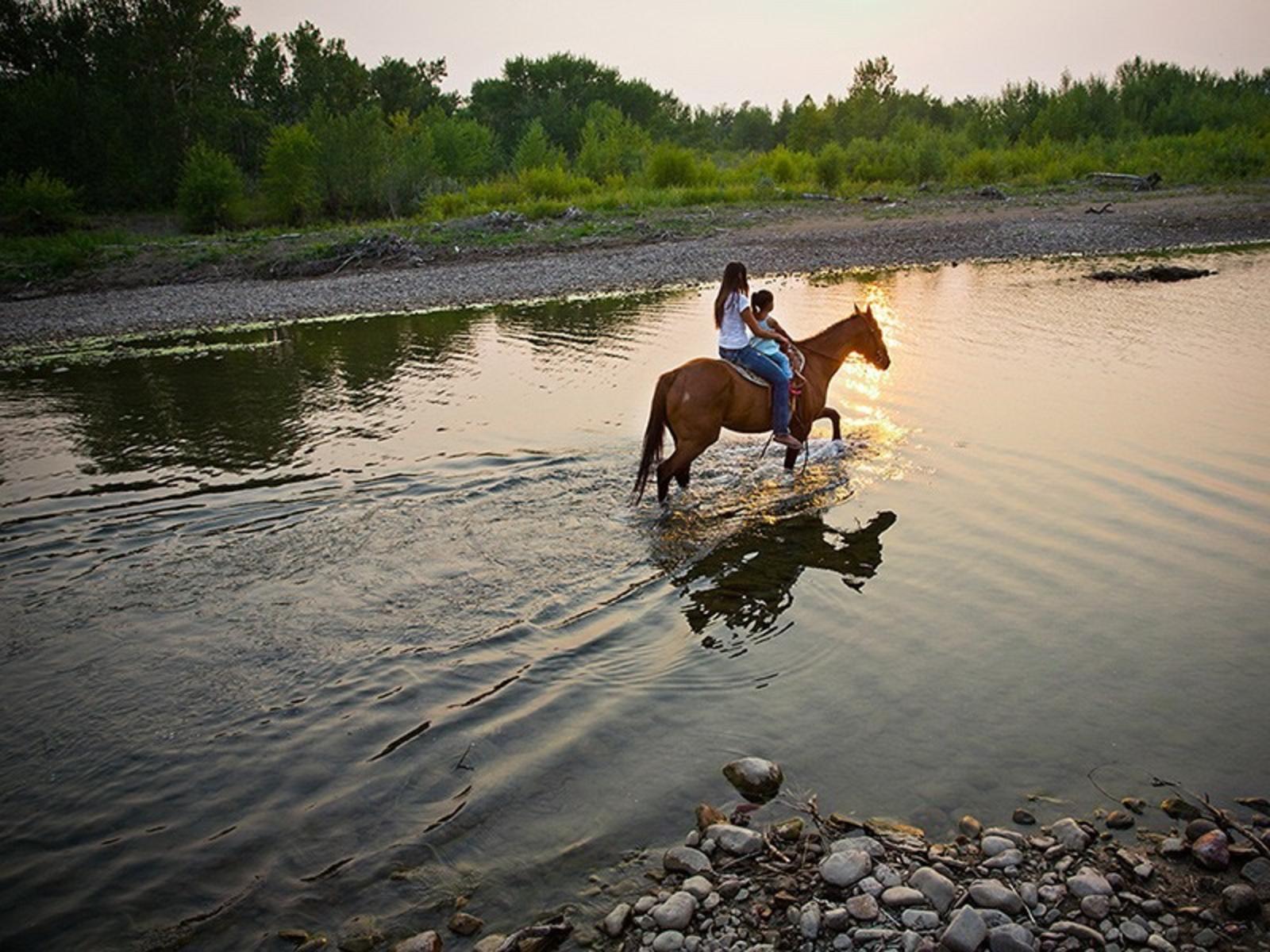 Kendall Edmo takes her daughter on a horseback ride through Blackfeet country in northern Montana. Photo courtesy Rebecca Drobis (rebeccadrobis.com)