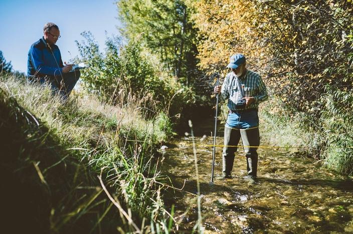 Bryce Contor and Wyatt Penfold measure flows in an irrigation canal that contributes to incidental recharge. Photo by Camrin Dengel