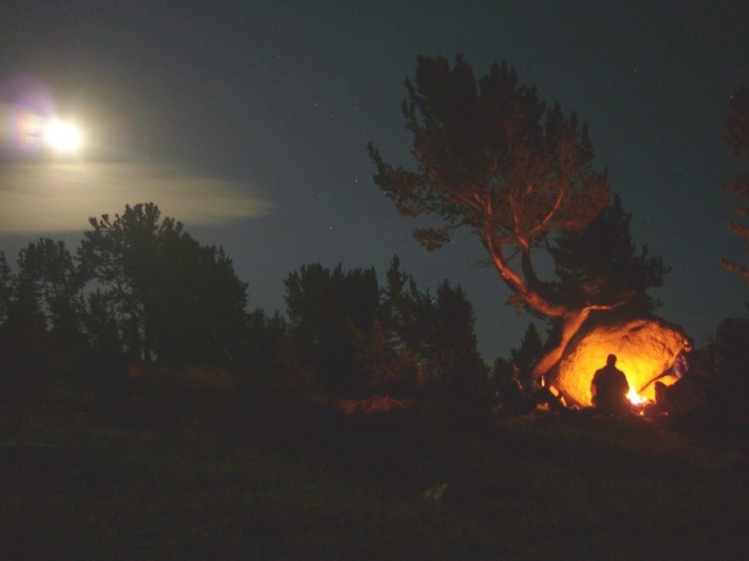 High in the Beartooths above Island Lake, moonlight and firelight illuminate a campsite.  Photo courtesy Jim Hagengruber 
