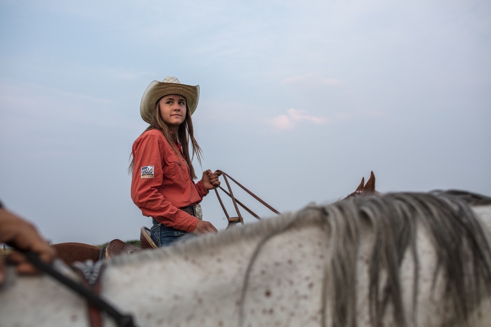 Irene Johnson rides with her sister Sadie as they exercise their horses the evening before their first rodeo of the season. Photo by Louise Johns