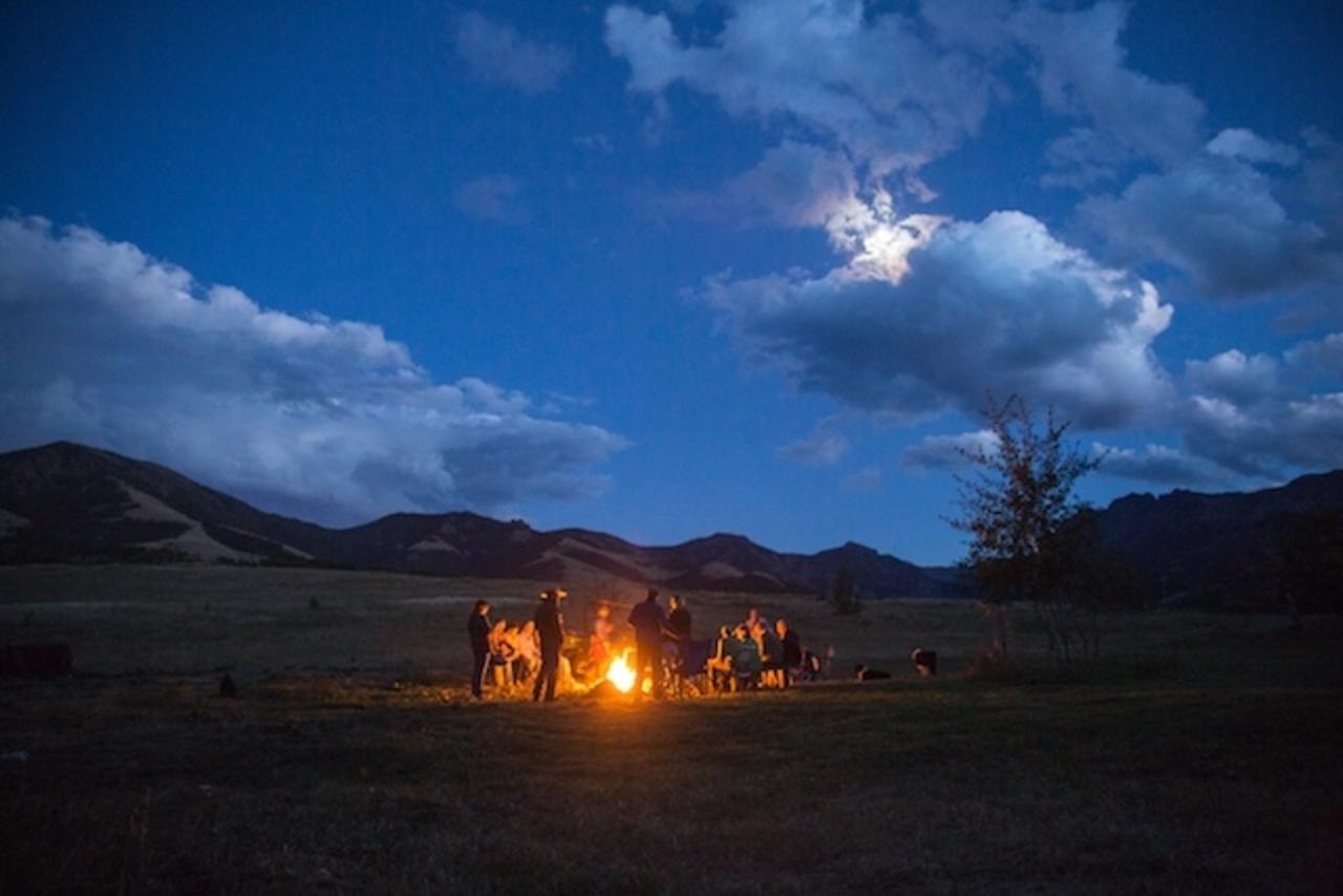 After a day of exploring at the Anderson Ranch, guests partaking in a Common Ground Project outing, gather around a campfire and discuss issues shaping the Greater Yellowstone Ecosystem before climbing into a tipi.  Photo courtesy Louise Johns  (http://www.louisejohnsphoto.com)