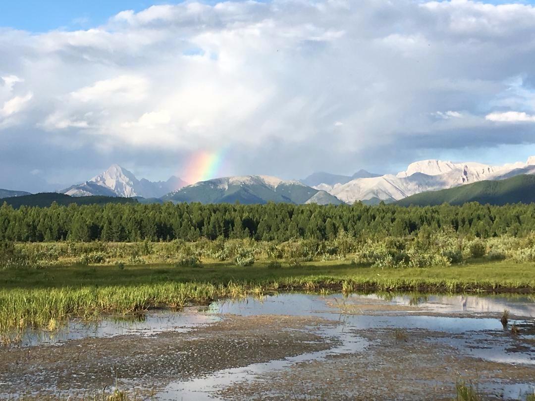 A rainbow highlights the skyline of Horidol Saridag with Delger Khan, the tall peak, towering in the background. This was one of the valleys that served as Watters' carnivore study areas. Photo courtesy Rebecca Watters