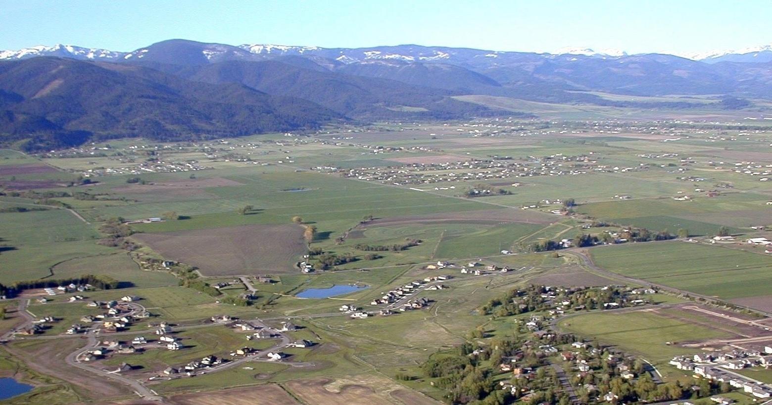 How can Greater Yellowstone's globally-renowned wildlife migration corridors, like those involving elk, above, endure when faced with development patterns like the one above? Not only will these animal pathways disappear but so, too, will the pastoral landscapes and the farming and ranching families living on them. To save both, FutureWest says, there needs to be a plan that fosters wise decisions and helps to preserve rural traditions. 