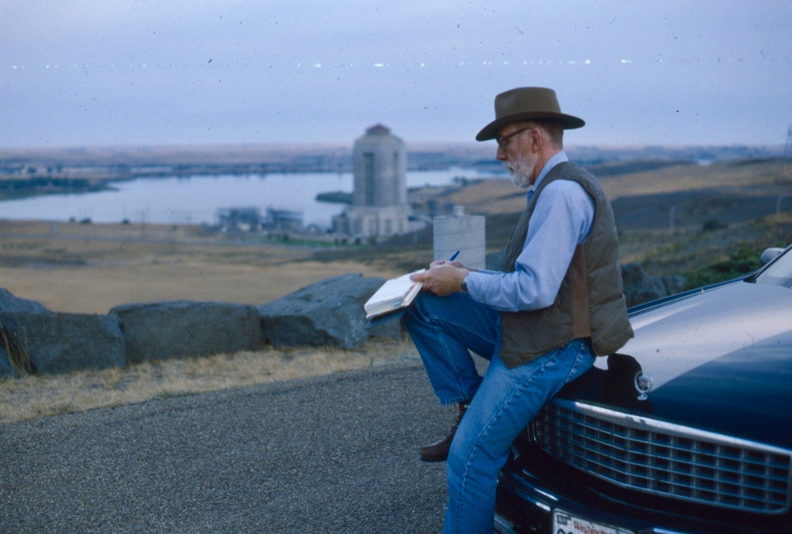 Ivan and Carol Doig spent many seasons traveling across Montana as he compiled new material for books which figured as the backdrop for his stories. Here he is taking notes and making observations at Fort Peck, created by the Missouri River in northeastern Montana. Photo courtesy Carol Doig/MSU Library Doig Archives
