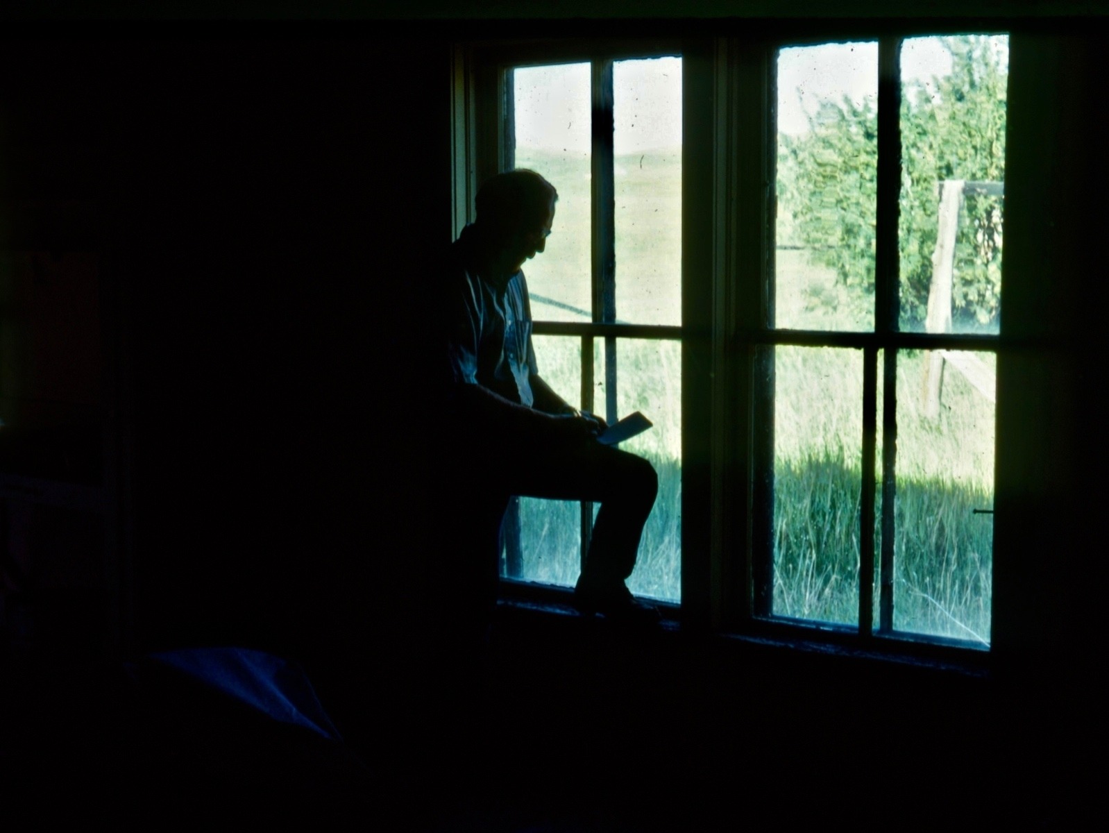 Doig, when in his prime, trying to instill the lessons of history into his work. Here he absorbs the vibe in an abandoned farm house where heart-felt dreams rose, fell part like a heartache and drifted away. Photo by Carol Doig, courtesy MSU Library Doig Archives 