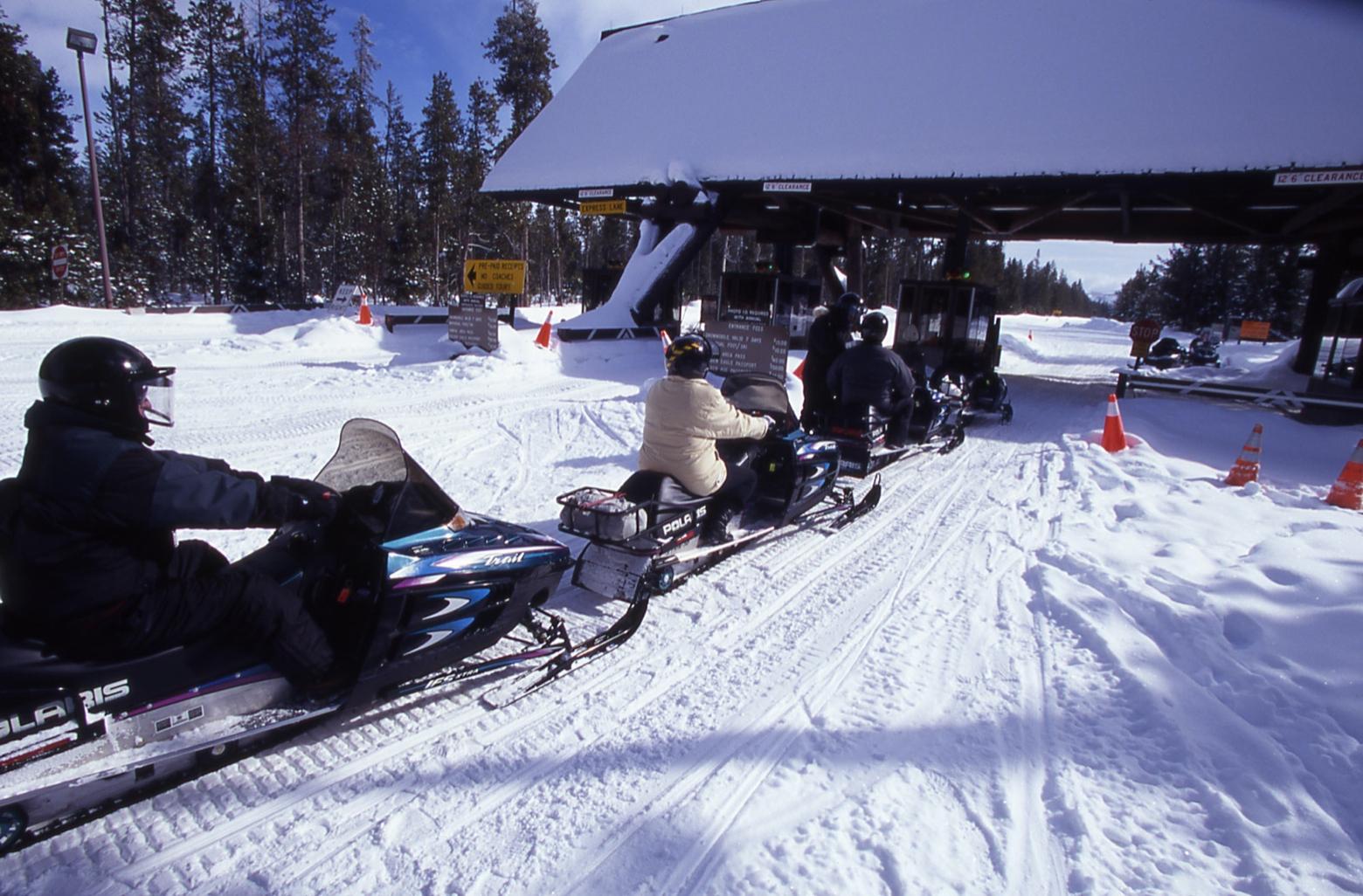 Snowmobilers, in the old days, wait to enter Yellowstone. Photo courtesy NPS.