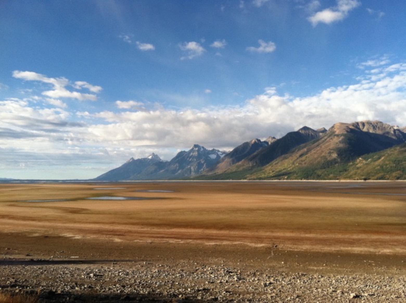 Jackson Lake in Grand Teton National Park, drained of its reach in a low precipitation summer and when downstream water users in Idaho—potato farmers—exercised their water rights to flows in the Snake River. Photo by Todd Wilkinson