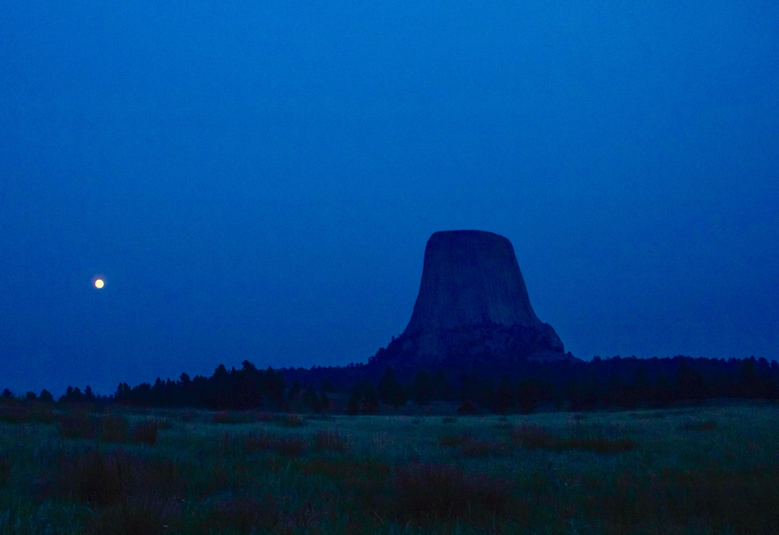 A full moon begins its rise toward to the flat-topped pinnacle of Devils Tower (Bear Lodge). A number of indigenous tribes not only treated Bear Lodge as a holy destination but together with charting the stars navigated their way around the high plains according to the seasons. Photo courtesy National Park Service 