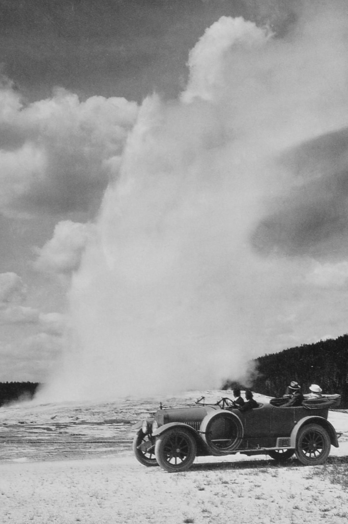 Early auto visitors drive literally up to the cone of Old Faithful Geyser across fragile geothermal crust. Photographer unknown/courtesy NPS