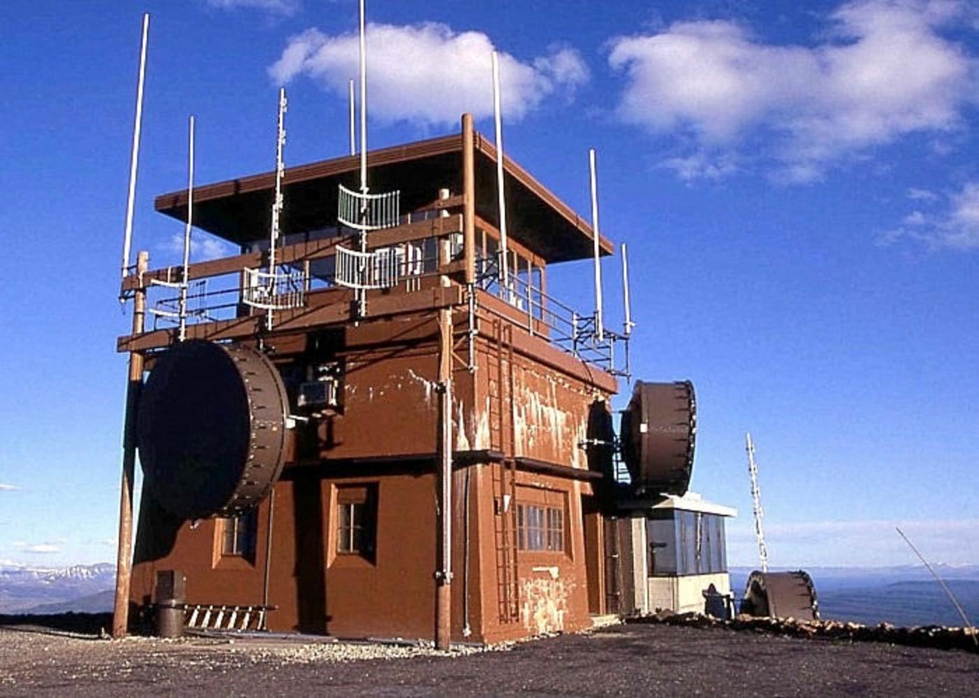 The old fire lookout on Mt. Washburn was originally built to be a perch for rangers to quickly identify lightning-caused wildfires and over the years has grown in its size. While some claim the addition of antennae to enhance cell phone reception is unsightly, a bigger criticism is how it allows the digital world to more of Yellowstone. Photo courtesy NPS