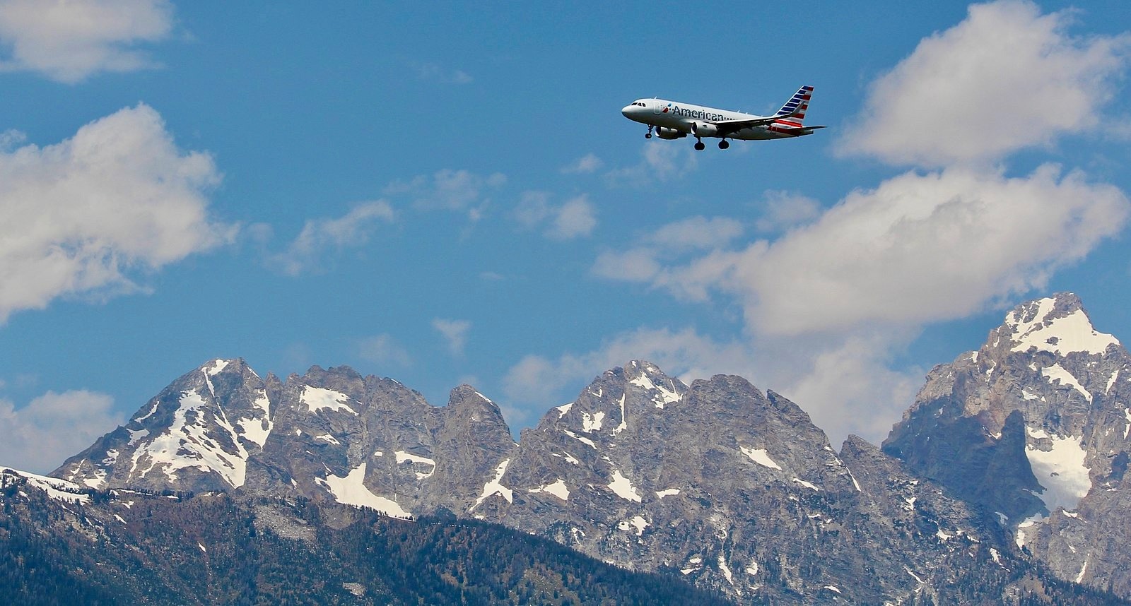 The tradeoffs of seeking prosperity: When Interior Secretary James Watt approved an extended special use permit for the Jackson Hole Airport in Grand Teton National Park in 1983, it not only cemented the presence of the airport but laid down the foundation for the facility to expand, the runway to be lengthened and number of flights to markedly increase.  A secondary impact is that it attracted fresh legions of second home owners and set off a development building boom. In addition, the fenced airport grounds represent a significant obstacle to wildlife movement and the sounds of jet aircraft detract from the setting. Photo courtesy Wikimedia/ WikiSniki17/Share-Alike 4.0 International License