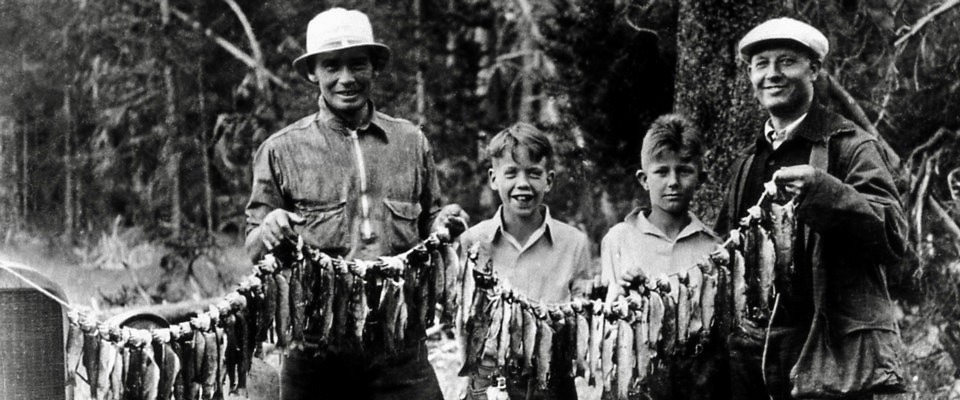 A band of fishing folk, young and old,  pose with their catch in Yellowstone decades before the park imposed strict catch and release regulations. Photo courtesy NPS