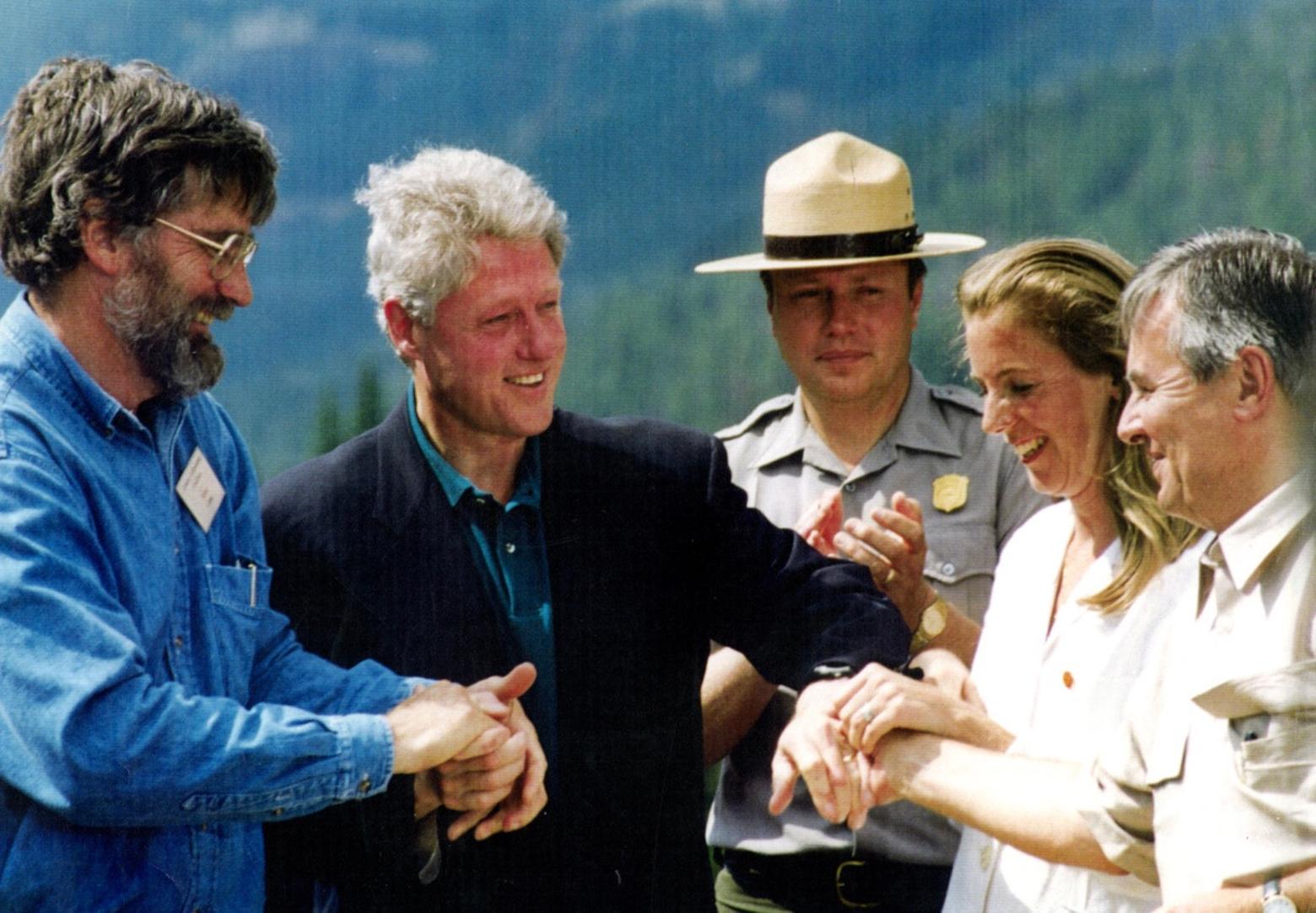 Postive outcome after a few nail-biting years: In August 1996, a momentous agreement was announced that stopped the threat of the New World Mine being built on the doorstep to Yellowstone. Taking part in the signing, witnessed by a few hundred people who looked on, were Mike Clark an next to him, left to right,: President Bill Clinton, Yellowstone Superintendent Mike Finley, Katie McGinty, director of The White House Office on Environmental Quality, and Ian Bayer, CEO of Canadian mining company, Hemlo Gold that owned the mine through corporate giant, Noranda. Photo courtesy Mike Clark/MSU Library Special Collections
