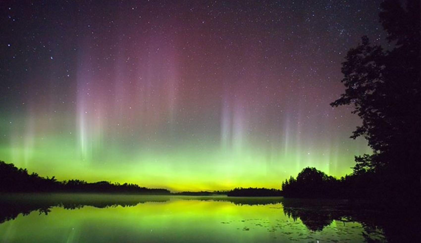 Aurora Borealis—the Northern Lights—glows above a lake in the Boundary Waters. Photo courtesy elyminnesota.com