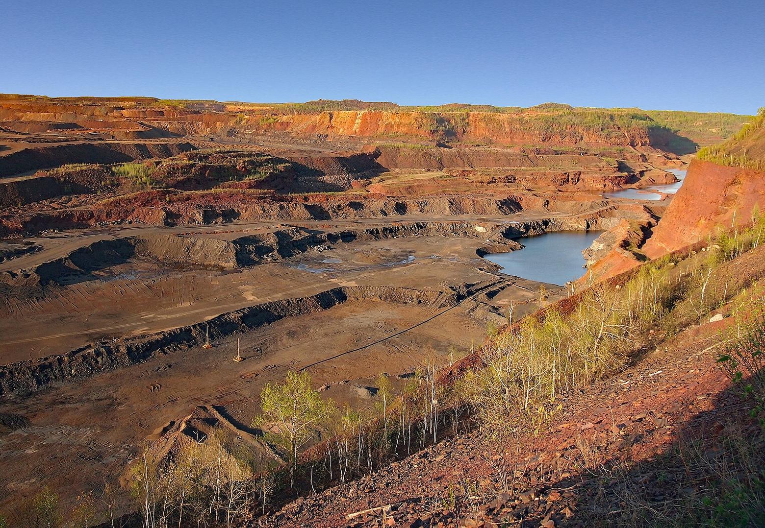 Butte, Montana? No, its Upper Midwest doppelgänger, Hibbing, Minnesota, where mining for iron ore created giant open pits that gnawed out swaths of the great North Woods. Rough and tumble, a town of hard-working immigrants like Butte, Hibbing seems an unlikely place, perhaps, for producing a force of nature whose poetry would command universal resonance. Pictured here is the Hull-Rust-Mahoning Open Pit Iron Ore Mine from an overlook on the edge of Hibbing. Dylan road his motorcycle as a teenager through some of the pits. Photo courtesy National Register of History Places, Ref: 66000904 