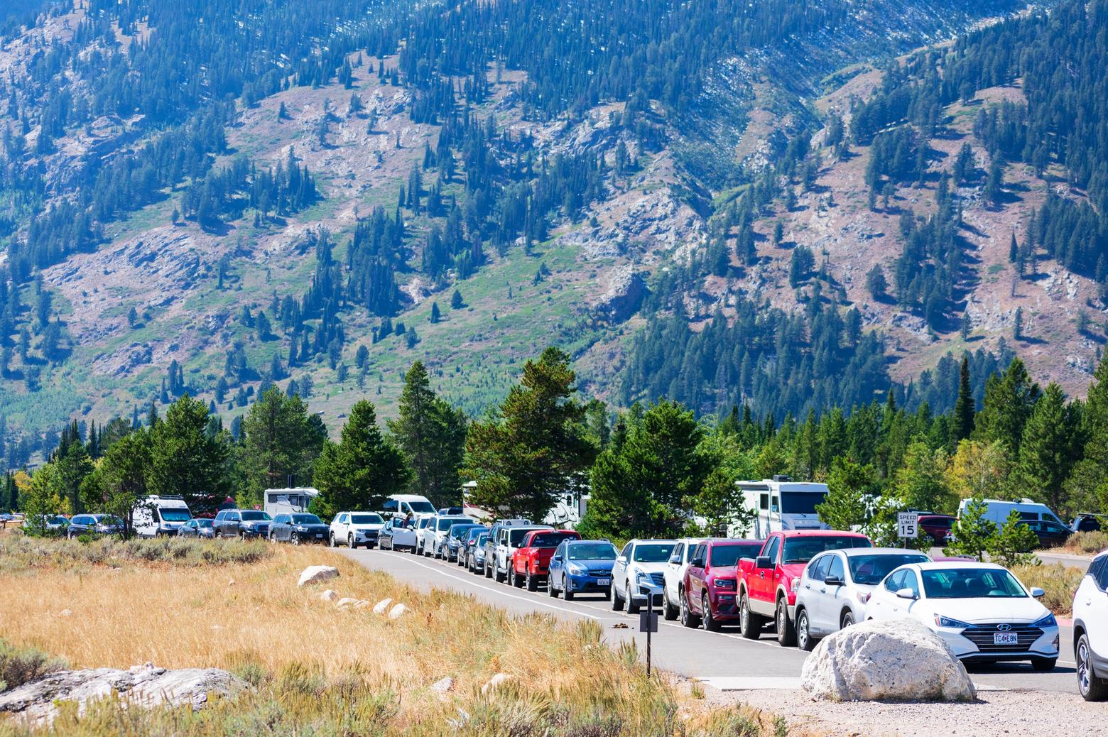 Just off the eastern shore of Jenny Lake in Grand Teton National Park, a recently-expanded parking lot, built to address overcrowding, is now overflowing with huge numbers of visitors.  Photo from Michael Vi/ Shutterstock ID 1956459727/