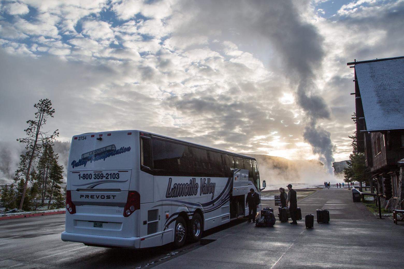 A commercial bus arrives at Old Faithful in Yellowstone. Bus tours bring huge crowding impacts to national parks and a small excise tax imposed on companies and passengers could generate significant revenue to be applied to landscape protection. Photo courtesy Yellowstone National Park