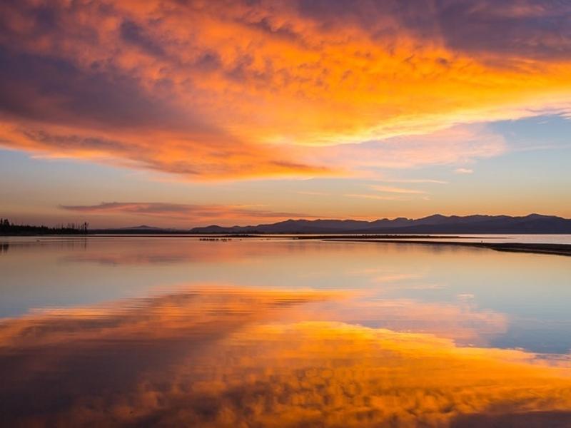 Yellowstone Lake's water reflects more than sunset's glow