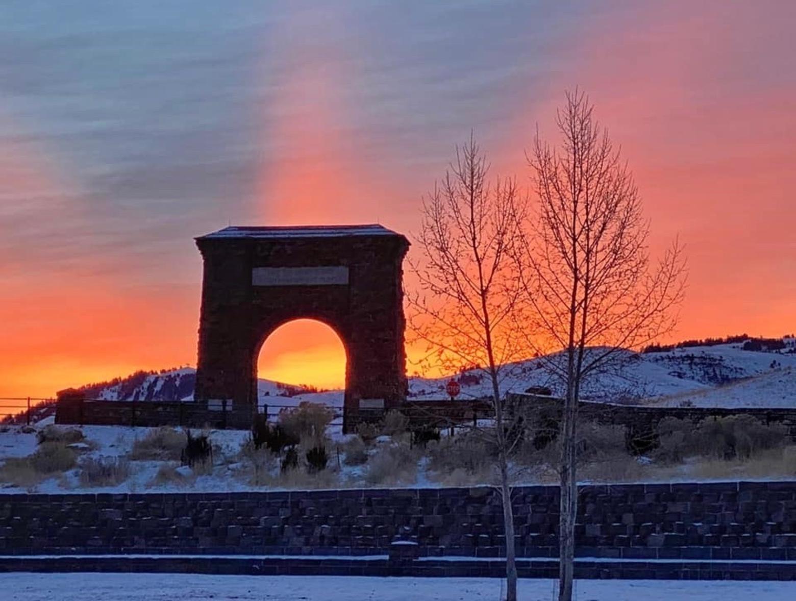 Roosevelt Arch rises into the air of a gloaming sunset on the edge of Gardiner, Montana at the northern entrance to Yellowstone. Photo courtesy Golding/Bumann
