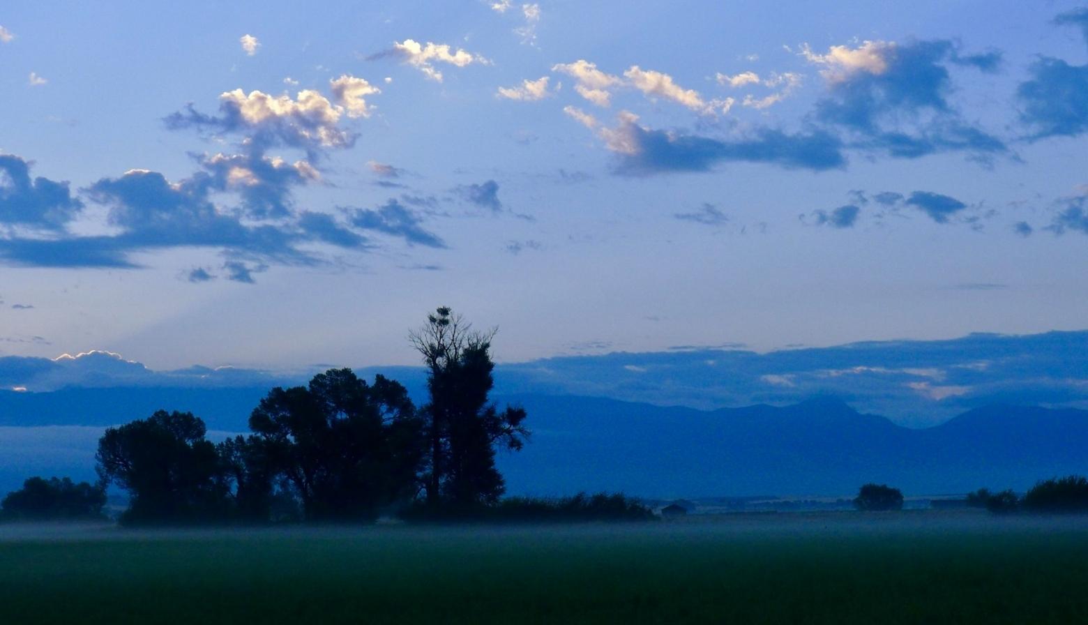 The Gallatin Valley, looking toward the Bridger Mountains, bathed in soothing twilight. "We all love this place so much it hurts when we witness changes that seem beyond our control," said the late businessperson, farmer and philanthropist Tim Crawford who took this photograph. "But you know what, there's a lot we can do. The first is to become informed and the second is to use our knowledge to take action and try to make things better." Photo by Tim Crawford