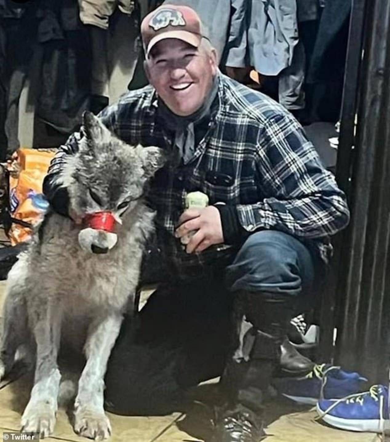 Cody Roberts mugs with the adolescent female wolf he crippled with his snowmobile. Photo courtesy Cowboy State Daily