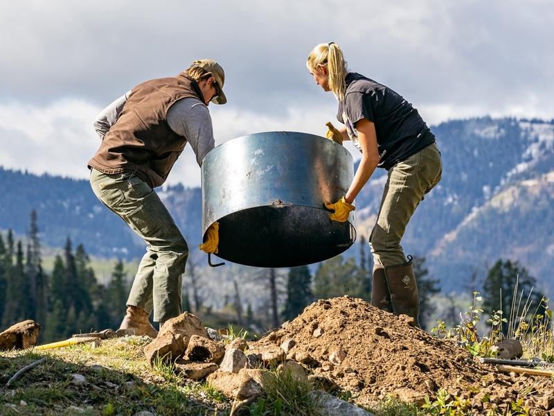 Workers install a fire ring at a campground for Friends of Bridger-Teton